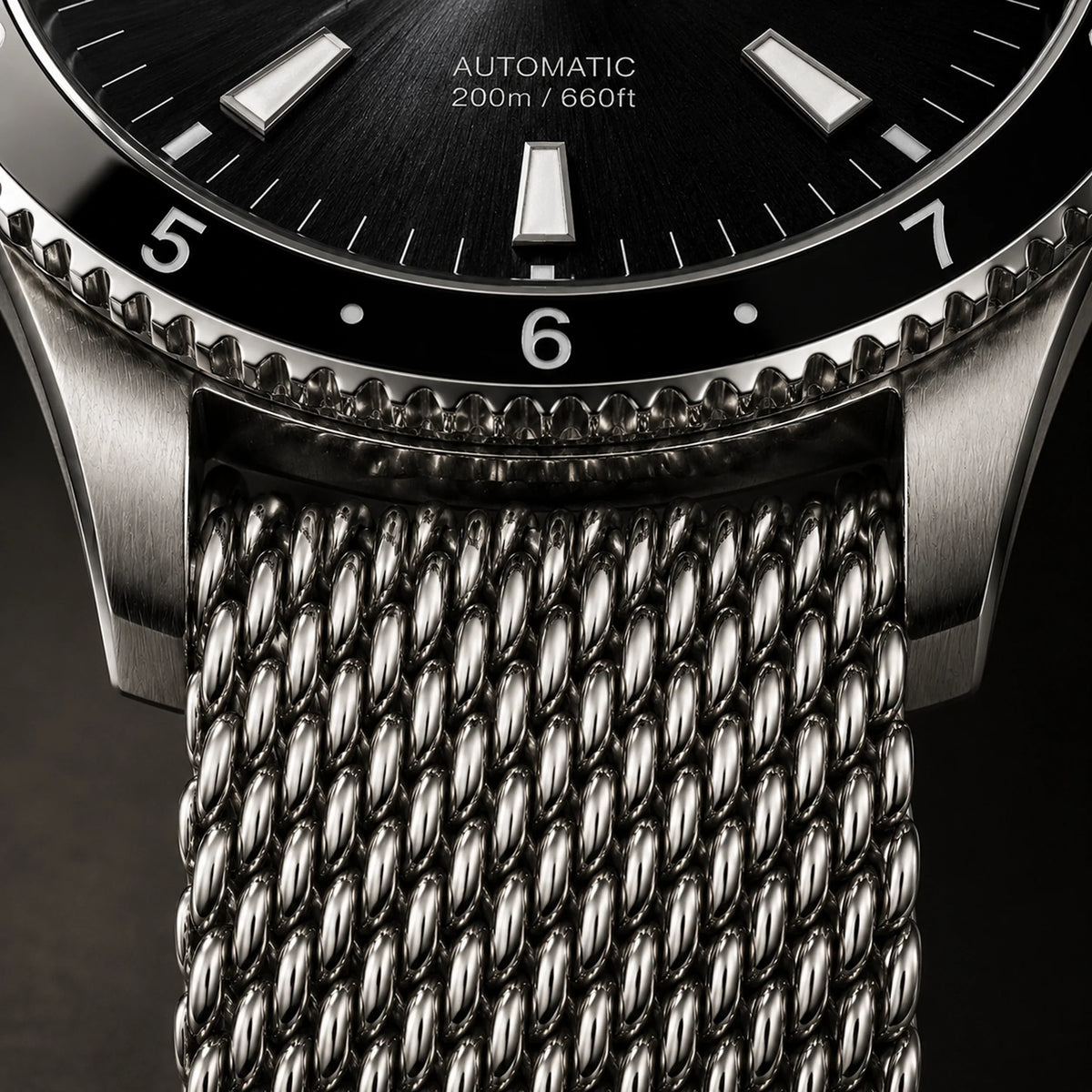 Close-up of the E.L.C. Riviera Signature Silver Black watch showing its black dial, black rotating bezel, brushed silver-tone case, and textured silver mesh bracelet.