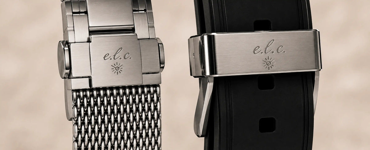 Close-up of E.L.C. watch clasps showing a silver mesh bracelet and black rubber strap with engraved E.L.C. logos.