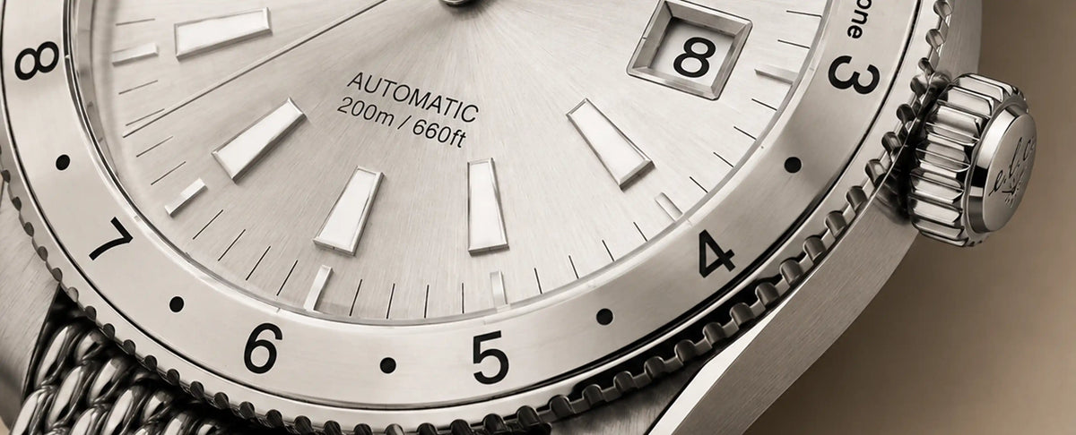 Close-up of the E.L.C. Riviera Signature Silver White watch showing its sunburst dial, date window, bezel, and crown.